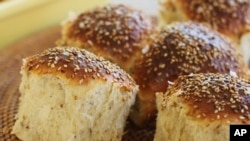 FILE - Sesame dinner rolls sit on a mat in Concord, N.H., on Oct. 12, 2015. (AP Photo/Matthew Mead, File)