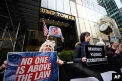 Para pengunjuk rasa berkumpul di luar Trump Tower, Jumat, 31 Maret 2023, di New York. (Foto: AP)