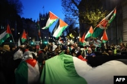 Protesters hold Palestinian flags and banners as they take part in a National March for Palestine in central London on Nov. 25, 2023.