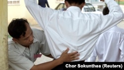 In this file photo, a Cambodian school security official searches a student for exam 'cheat sheets' at the gates of a school in Phnom Penh. (REUTERS/Chor Sokunthea)