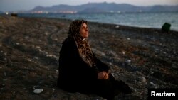 FILE - Amoun, 70, a blind Palestinian refugee who lived in the town of Aleppo in Syria, rests on a beach moments after arriving along with another 40 on a dinghy in the Greek island of Kos, crossing a part of the Aegean Sea from Turkey to Greece, Aug. 12, 2015.