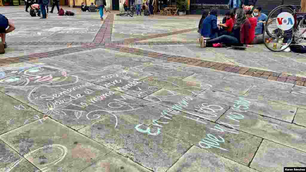 J&#243;venes escriben en el piso mensajes relacionados con la paz de su pa&#237;s, en un parque del centro de Bogot&#225;.