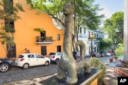 A statue of a cat stands in Old San Juan, Puerto Rico, Thursday, Nov. 3, 2022. Cats have long strolled through the cobblestone streets of the historic district and are so beloved they even have their own statue in Old San Juan. (AP Photo/Alejandro Granadillo)