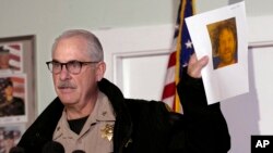 Phil Johnston, the assistant sheriff for Tehama County, Calif., displays a booking photo, from a prior arrest, of Kevin Janson Neal, during a news conference, Nov. 15, 2017, in Rancho Tehama Reserve, Calif. Neal went on a shooting spree Tuesday before being shot and killed by Tehama County sheriff's deputies.