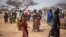 FILE - Refugees walk in a camp for internally displaced persons, in northern Burkina Faso, June 20, 2021.