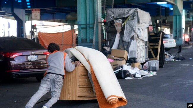 Un hombre empuja sus pertenencias durante un desalojo de un campamento de deseamparados en San Francisco, California, el 29 de agosto de 2023.