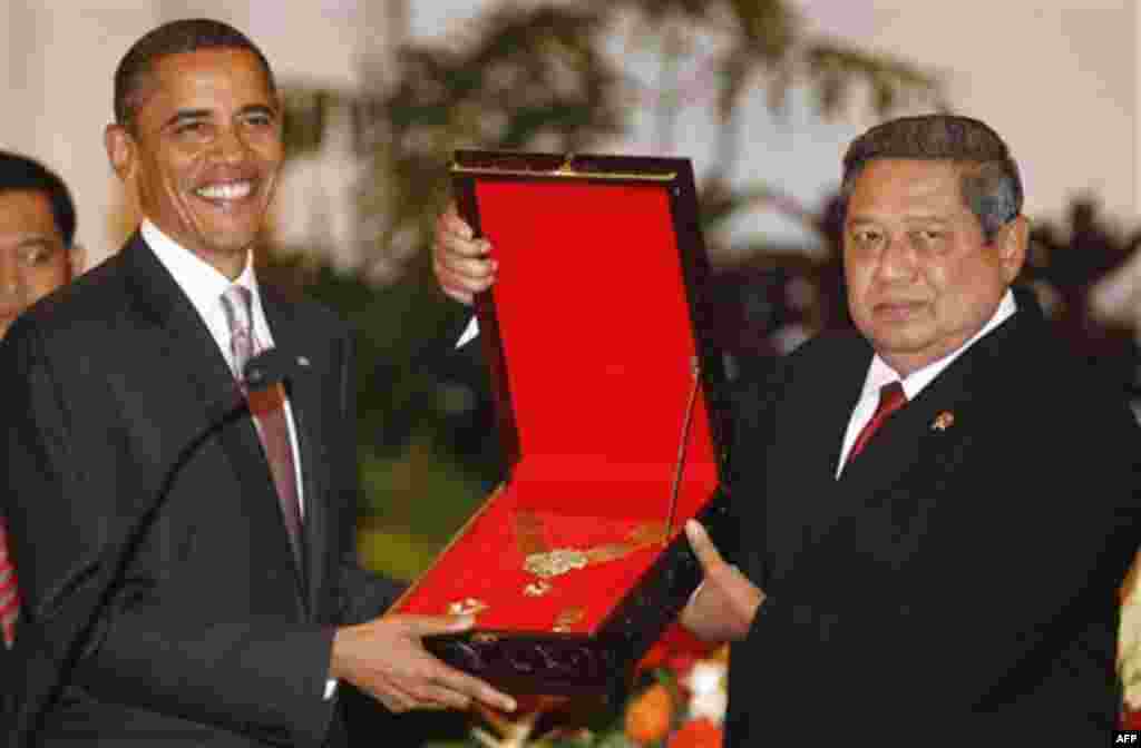 President Barack Obama accepts an award on behalf of his late mother Stanley Ann Dunham, for her work in Indonesia, from Indonesian President Susilo Bambang Yudhoyono, during the state dinner at the Istana Negara in Jakarta, Indonesia, Tuesday, Nov. 9, 20