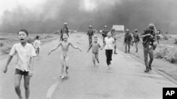 FILE - South Vietnamese forces follow children, including 9-year-old Kim Phuc, center, as they run down Route 1 near Trang Bang after an aerial napalm attack on suspected Viet Cong hiding places, June 8, 1972.