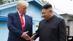 资料照片：特朗普总统和朝鲜领导人金正恩在韩朝非军事区板门店会晤时准备握手。(2019年11月30日)