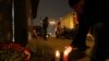 Un hombre prende una vela en el sitio de una explosión que mató a un bloguero ruso partidario de la invasion de Ucrania en San Petersburgo, Rusia, el 2 de abril de 2023.