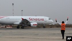 Un contrôleur de l'aéroport dirige un Airbus du Senegal Airlines qui va décoller à Dakar