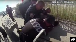 In this photo taken from police body cam video, New York Police officers arrest a man on a boardwalk, June 21, 2020, in New York.
