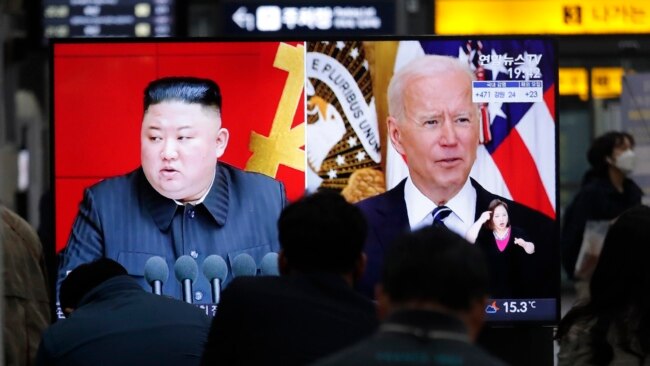 In this March 26, 2021, file photo, commuters watch a TV showing file imagea of North Korean leader Kim Jong Un and U.S. President Joe Biden during a news program at the Suseo Railway Station in Seoul, South Korea.
