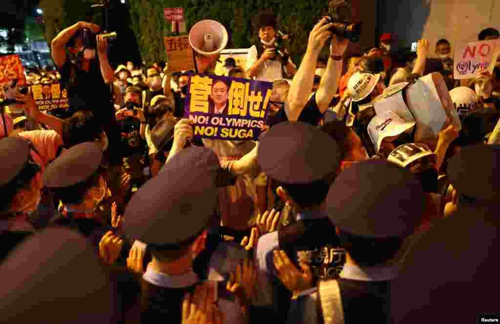 Police officers try to push back protesters outside the stadium Olympic Stadium in Tokyo, Japan - July 23, 2021.