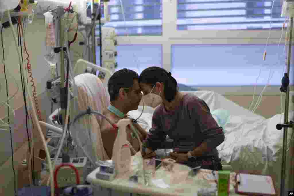 Amelie and Ludo Khayat hold each other during a visit at the COVID-19 intensive care unit of the la Timone hospital in Marseille, southern France.&nbsp;Ludo, 41, is recovering from spending 24 days in a coma and on a ventilator in a COVID-19 intensive care unit. Amelie began visiting her husband daily after he started to test negative for the virus.