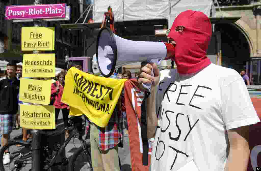 Seorang aktivis kelompok hak asasi manusia Amnesty International memakai masker dan meneriakkan seruan untuk membebaskan Pussy Riot di Munich, Jerman. (AP/dapd, Lennart Preiss)