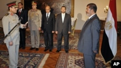 Egyptian President Mohammed Morsi swears in newly-appointed Minister of Defense, Lt. Gen. Abdel-Fattah el-Sissi, in Cairo, Egypt, Sunday, Aug. 12, 2012.