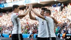 Mario Gomez célèbre avec ses coéquipiers Mats Hummels, au centre, et Julian Draxler, à droite, après un but lors du match de football Euro 2016 de 16 matches entre l'Allemagne et la Slovaquie, au stade Pierre Mauroy à Villeneuve d'Ascq, 2016.