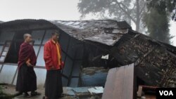 Biksu muda melintasi rumah yang roboh akibat gempa berkekuatan 6.9 di Gangtok, India (19/9).