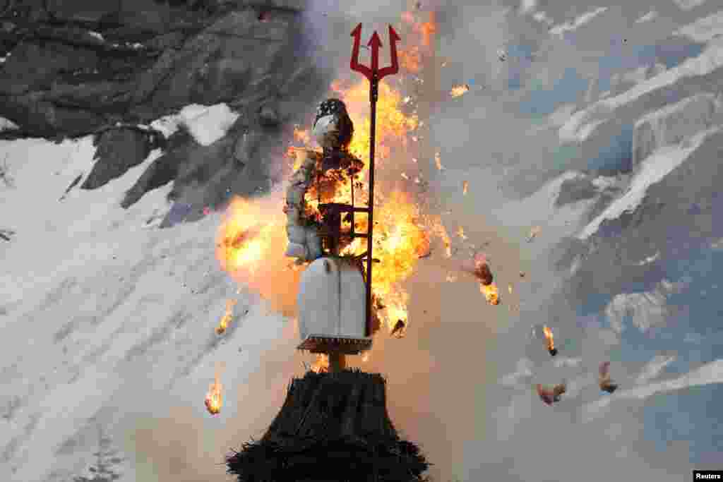 The Boeoegg, a snowman made of wadding and filled with firecrackers, is burning in a bonfire on the landmark of Devil&#39;s Bridge in the Schoellenen Gorge near the Alpine resort of Andermatt, Switzerland, April 19, 2021.