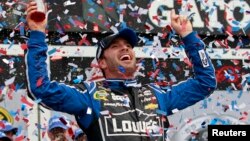 El piloto Jimmie Johnson celebra el triunfo al ganar la serie Copa Sprint de NASCAR en la pista internacional de carreras en Daytona, Florida.