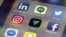 The Vero app, center, is displayed on an iPhone in New York, March 1, 2018. Instagram users fed up with ads, with the end of chronologically displayed posts and the lack of granular privacy controls are flocking to Vero.