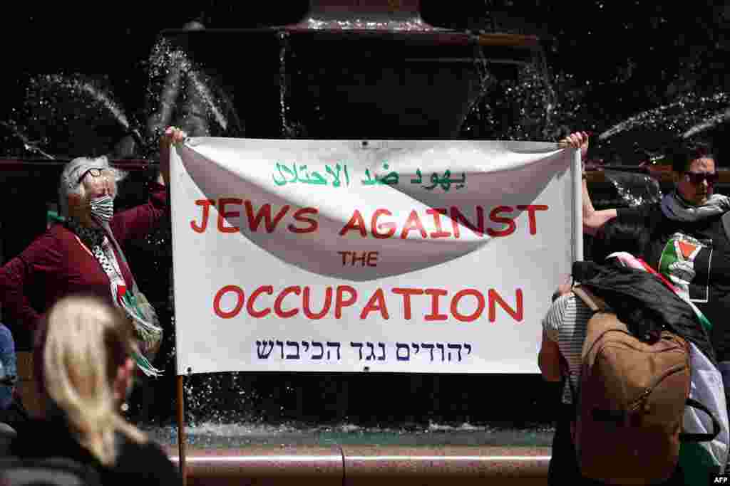 Članovi australske palestinske i jevrejske zajednice drže zastave i plakate dok učestvuju na skupu u Sidneju 29. oktobra 2023.