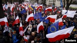 Des manifestants hissant les drapeaux polonais et de l'Union européenne lors d'une manifestation anti-gouvernementale devant la Cour constitutionnelle à Varsovie , en Pologne , le 12 déc 2015. REUTERS/Kacper Pempel - RTX1YD19