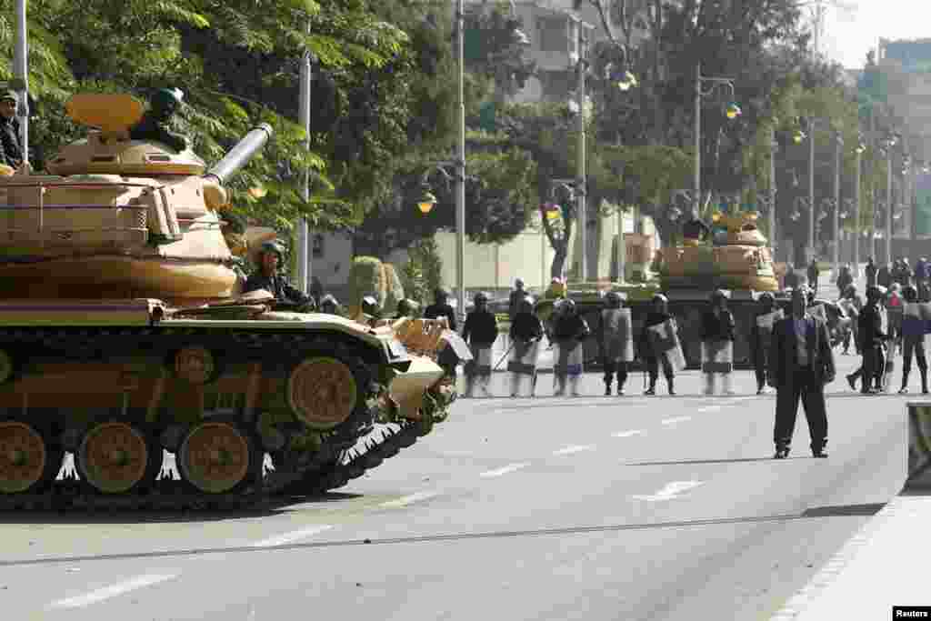 Army tanks and riot police are seen outside the presidential palace in Cairo, December 12, 2012. 