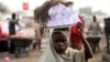 Girl hawks drinking water packed in sachets along street after days of religious clashes in the northern Nigerian city of Maiduguri, Aug. 4, 2009.