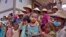 FILE - children and elders displaced from recent fighting between government troops and ethnic rebels in their area, wait for food distribution at a monastery in Namlan town, Myanmar's eastern Shan state, May 25, 2021.