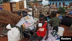 Zimbabwean children sit among salvaged possessions at a transit camp for over 100 families displaced by floods near the Tokwe-Mukorsi dam about 430km (267 miles) south of Harare, Feb. 13, 2014.