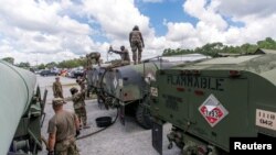 Des soldats de la Garde nationale de la Caroline du Sud transfèrent du carburant diesel en vrac dans des camions-citernes pour distribution avant l’ouragan Florence, à North Charleston, en Caroline du Sud, le 10 septembre 2018.