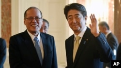 Philippine President Benigno Aquino III, left, and Japan's Prime Minister Shinzo Abe pose for photographers upon Aquino's arrival at the Akasaka State Guesthouse for their meeting in Tokyo, June 4, 2015. 