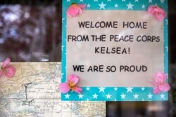 A welcome home sign for Peace Corps evacuee Kelsea Mensh, 22, hangs on her mother's door as the family reunites at their home in Dumfries, Va., April 1, 2020.