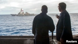 FILE - U.S. Secretary of Defense Ash Carter (R) speaks with U.S. Navy Cmdr. Robert C. Francis Jr on the USS Theodore Roosevelt aircraft carrier in the South China Sea.