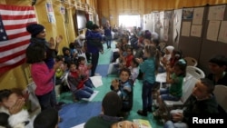 FILE - Syrian refugee children play as they wait with their families to register at the U.S. processing center for Syrian refugees, during a media tour held by the U.S. Embassy in Jordan, in Amman, Jordan, April 6, 2016.