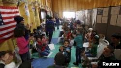 FILE - Syrian refugee children play as they wait with their families to register at the U.S. processing center for Syrian refugees, during a media tour held by the U.S. Embassy in Jordan, in Amman, Jordan, April 6, 2016.