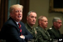 President Donald Trump, with Joint Chiefs Chairman Gen. Joseph Dunford and Marine Corps Commandant Gen. Robert Neller, speaks during a briefing with senior military leaders in the Cabinet Room at the White House in Washington, Oct. 23, 2018.