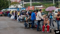 FILE - Patrons line up in a San Cristobal supermarket parking lot in shortage-plagued Venezuela, Jan. 22, 2015