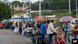 Patrons line up on a supermarket parking lot in San Cristobal, Venezuela, Jan. 22, 2015