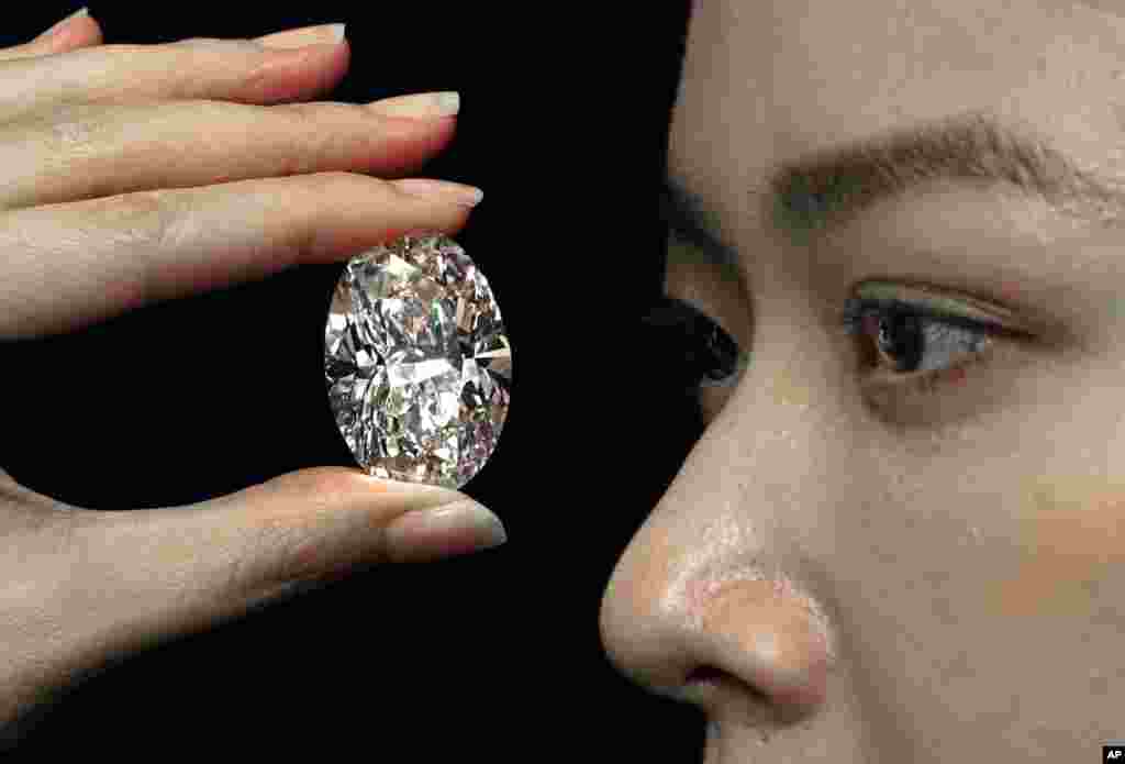 A 102.39 carat, D color, flawless diamond is displayed by a model at a Sotheby’s auction room in Hong Kong Monday, Sept. 28, 2020. It is the first time that a diamond this size will be auctioned without reservations in history. (AP Photo/Vince)