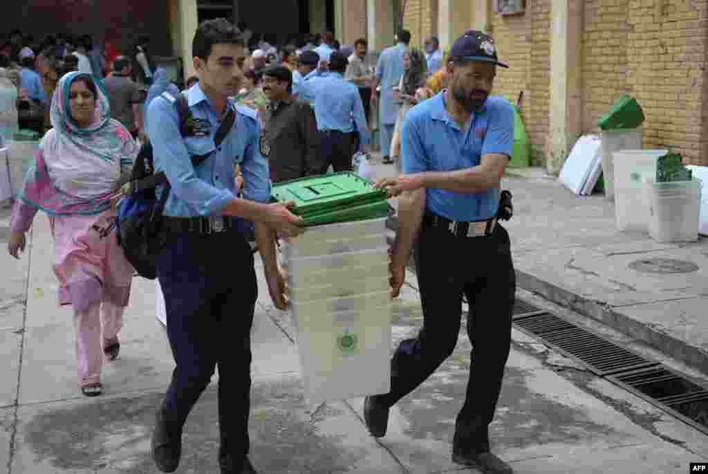 اسلام آباد پولیس کے اہلکار خواتین پریزائڈنگ افسران کے ہمراہ انہیں ملنے والا پولنگ کا سامان منتقل کر رہے ہیں۔