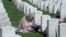 Una mujer visita la tumba de su hijo en el Cementerio Nacional de Arlington el 29 de mayo de 2022.