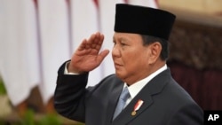 FILE - Indonesian President Prabowo Subianto salutes during the swearing-in ceremony of new cabinet ministers at the presidential palace in Jakarta, Oct. 21, 2024. Subianto left for China on Friday for his first international trip as president.