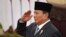 FILE - Indonesian President Prabowo Subianto salutes during the swearing-in ceremony of new cabinet ministers at the presidential palace in Jakarta, Oct. 21, 2024. Subianto left for China on Friday for his first international trip as president.