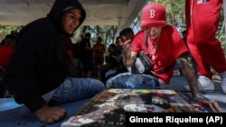 People play poleana, a board game invented in prison, before a tournament in Mexico City, Sunday, Nov. 17, 2024. (AP Photo/Ginnette Riquelme)