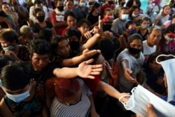 Residents affected by Typhoon Vamco gather during a distribution of face masks and relief goods in an evacuation center, in Rodriguez, Rizal province, Philippines, Nov. 13, 2020.