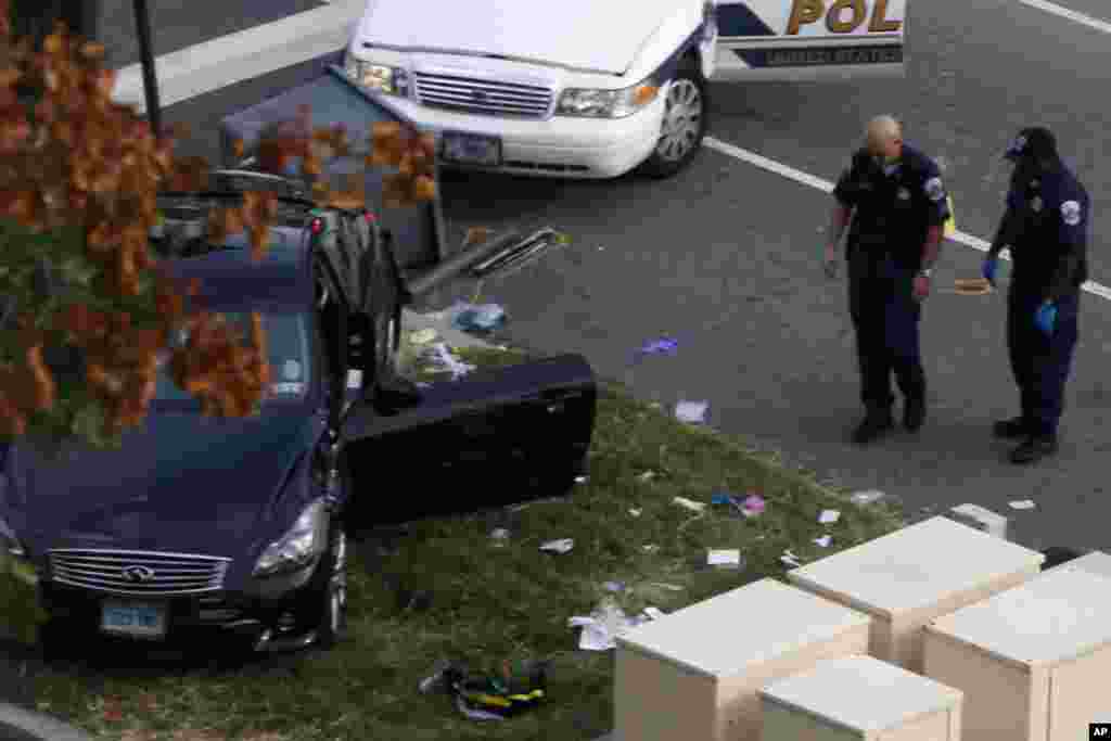 Capitol Police officers look at a car following a shooting on Capitol Hill.