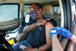 FILE - In this March 29, 2021, file photo, Brian Snipes receives a drive-thru vaccination at "Vaccine Fest," a 24-hour COVID-19 mass vaccination event in Metairie, La., just outside New Orleans.